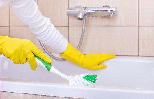 Carpet cleaner wearing protective gloves and footwear during a job